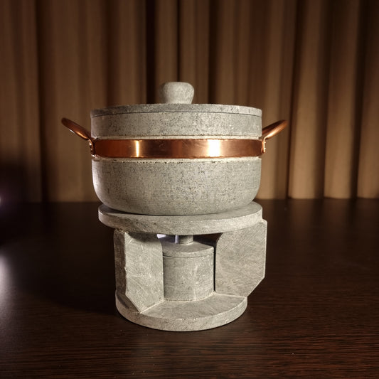 Juego de fondue de piedra esteatita de 1,5 litros con quemador sobre mesa de madera.